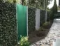 Preview: Hecke von Mobilane® als Zaun kombiniert mit farbigem Acrylglas und Gabionen.