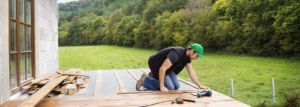 Ein Mann legt Holz auf einer Terrasse aus