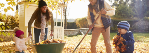 Kinder helfen Eltern, Herbstblätter im Garten zu sammeln